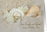 Daughter’s wedding, rings in beach sand with seashells and net card