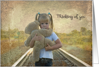 Thinking of you with sad child hugging a teddy bear on railroad tracks card