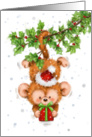 Cute little monkey hanging from holly, holding christmas present. card