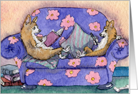 Corgi dogs sitting on sofa, reading a book and an ereader card