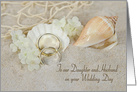 Daughter’s wedding, rings in beach sand with seashells and net card