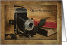 Retirement for photographer, vintage bellows camera with roll of film card