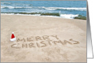 Merry Christmas In Beach Sand with a Santa hat card