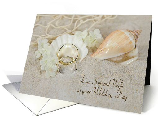 Son's wedding rings in beach sand with seashells and net card