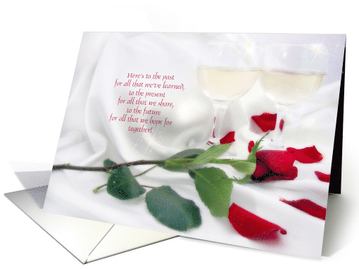 anniversary celebration with red rose and wine glasses on satin card