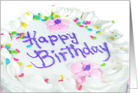 birthday cake with heart sprinkles on white icing and flowers card