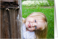 Hello, smiling little girl peeking around old wooden door card