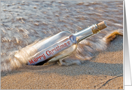 Merry Christmas message in a bottle on the beach card