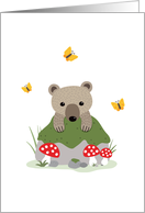 Bear cub and butterflies behind mossy forest rock card