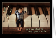 Thinking of you, miniature baby on piano keyboard, blank card