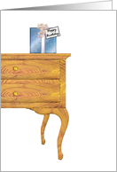 Birthday present sitting on top of chest of drawers card