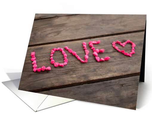Love written with pink stones on a wooden table card (1359988)