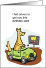 A funny cartoon kangaroo driving a car in Australian outback. card